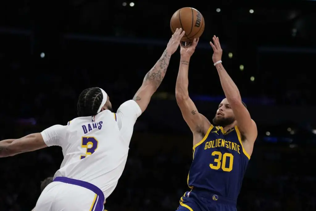 March 16th 2024; Los Angeles, California, USA; Los Angeles Lakers center Anthony Davis contests a Steph Curry jumper at Crypto.com Arena on Saturday night. Mandatory Credit: Adam Pantozzi-Getty Images